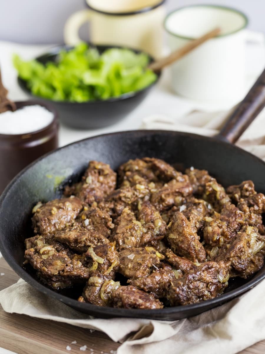 Chicken livers with onion on a cast iron pan.