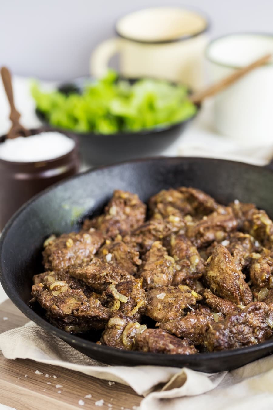 Chicken livers with onion on a cast iron pan.