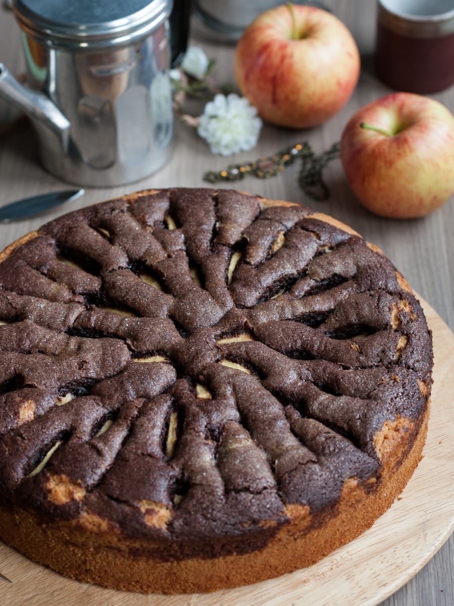 Chocolate apple cake on a wooden round tray.