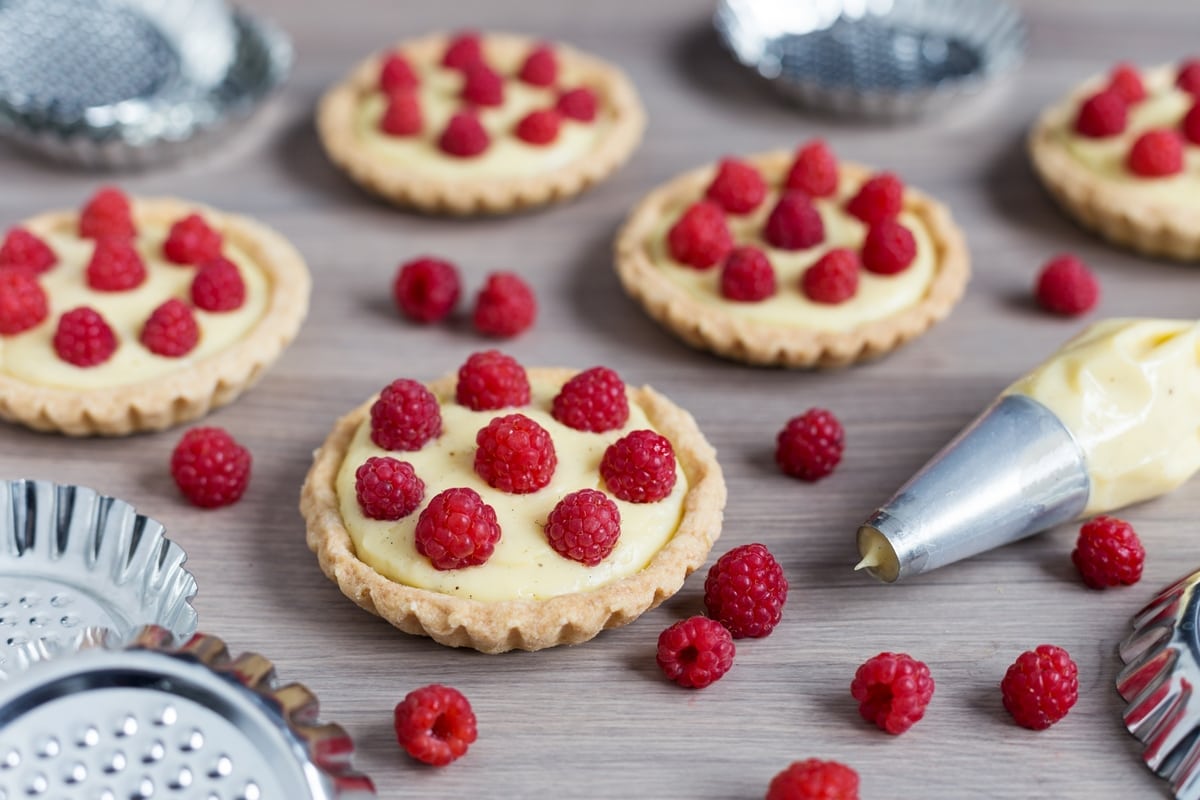 Home-made custard tarts decorated with freshly picked raspberries
