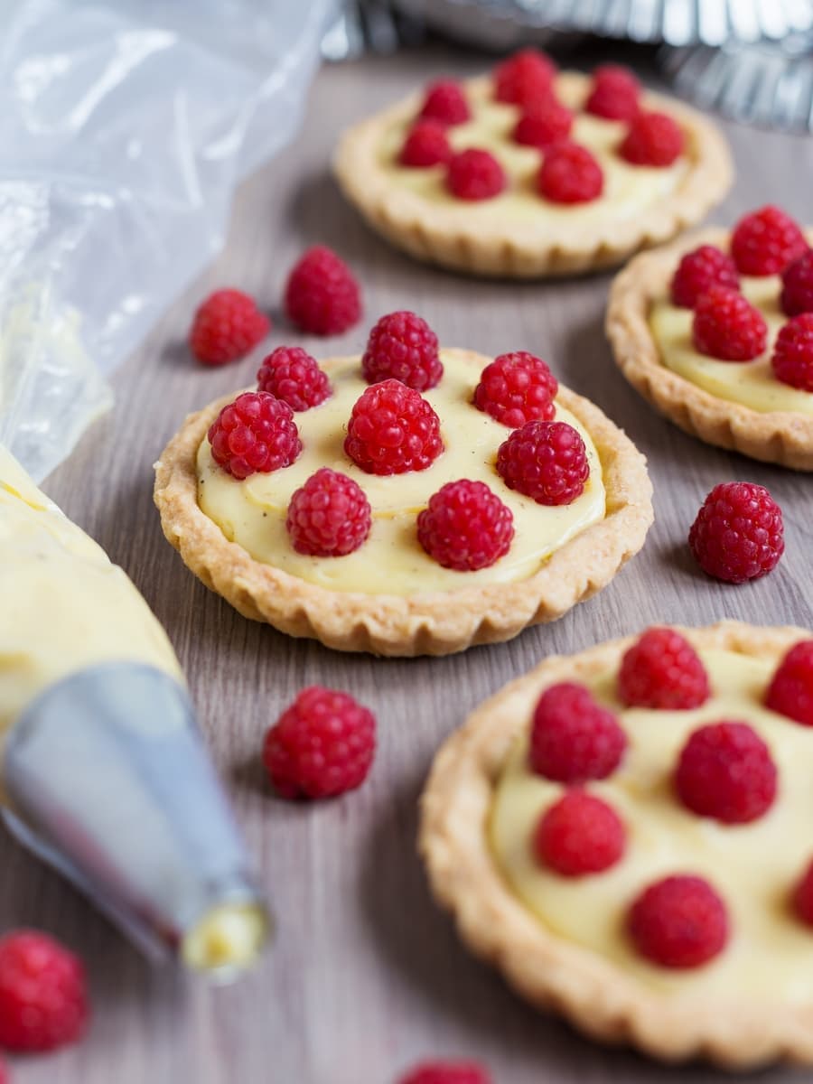 Home-made custard tarts decorated with freshly picked raspberries