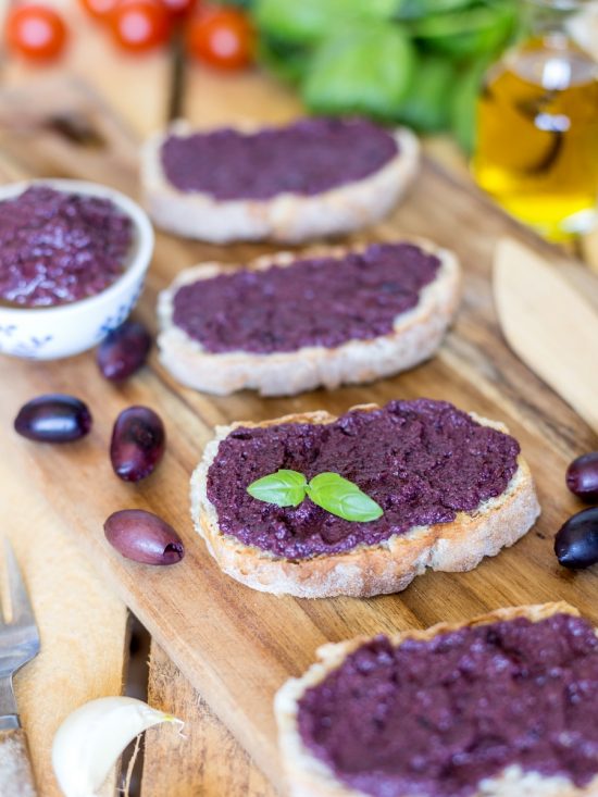 Black olive paté, or black olive paste, spread on bread is one of those lovely alternatives to the classic garlic and tomato bruchetta topping.