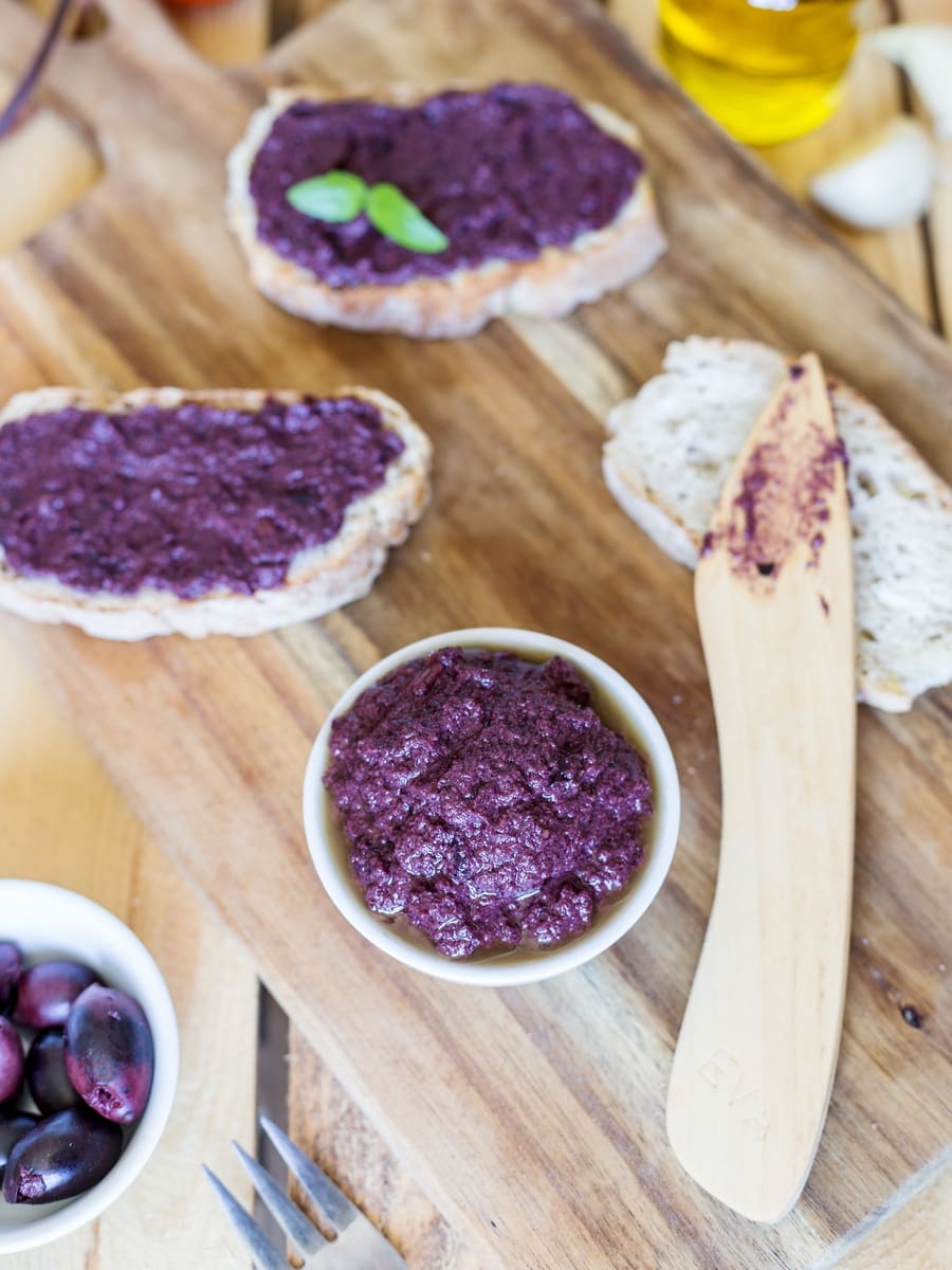 Black olive paté, or black olive paste, spread on bread is one of those lovely alternatives to the classic garlic and tomato bruchetta topping.