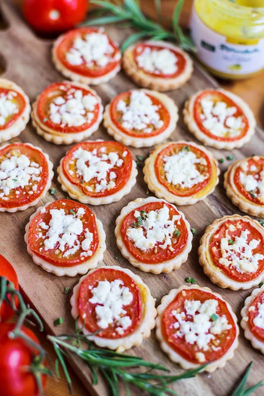 Tomato mustard tart miniatures on a wooden tray.