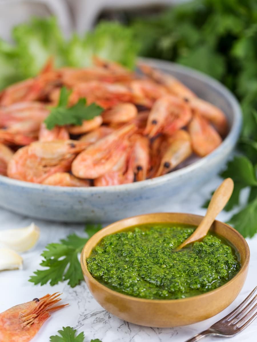A small bowl with nordic pesto and a large bowl filled with smoked shrimp.