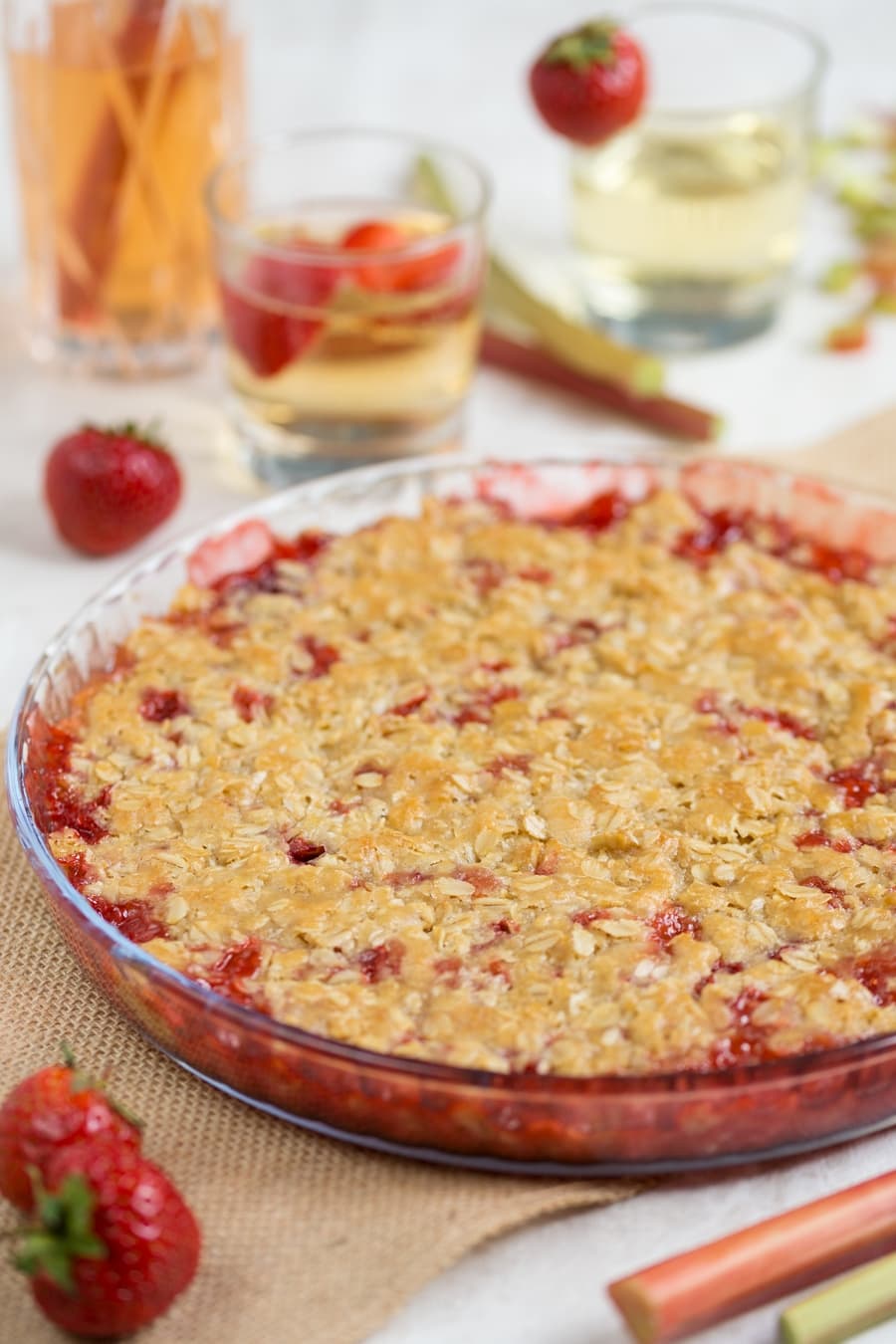 Baked strawberry rhubarb crisp, strawberry cocktails in the background.