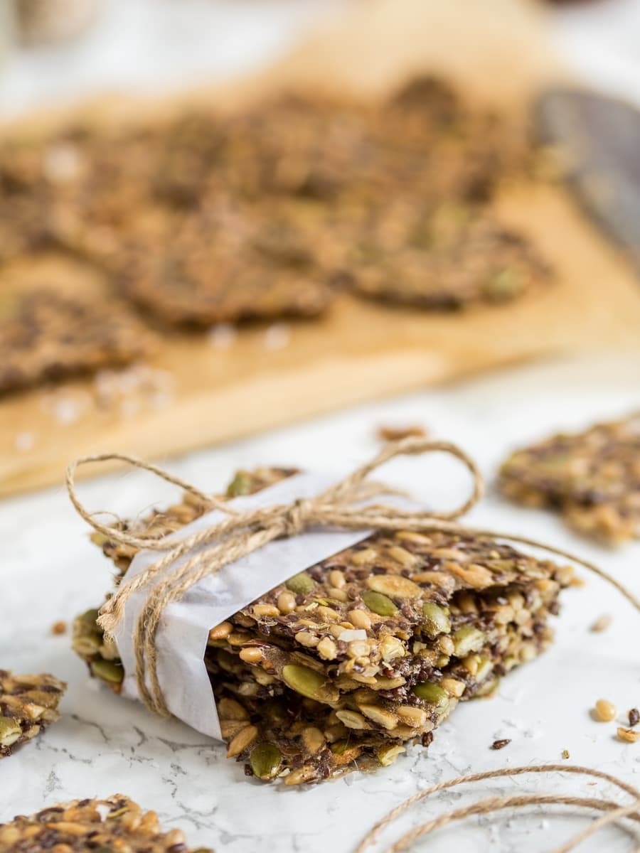 Seed crackers wrapped in white paper, with a jute twine ribbon.