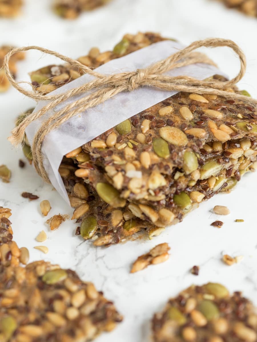 Homemade seed crackers, wrapped with white paper and jute twine.