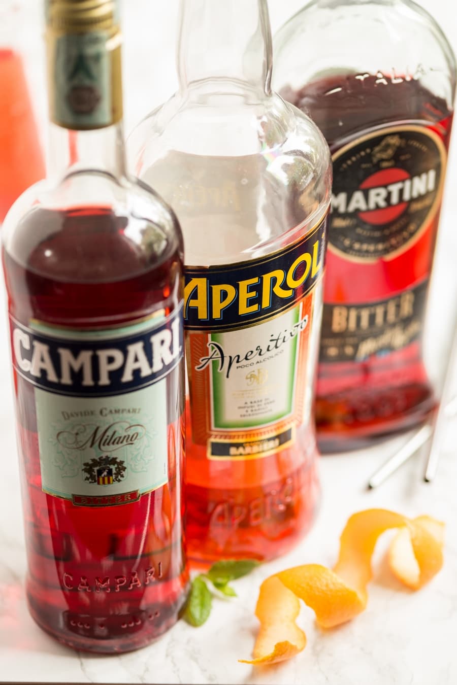 Three Italian bitters bottled: Campari, Aperol and Martini.