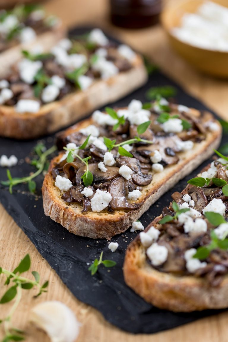Closeup of garlicky mushroom crostini with crumbed goat cheese.