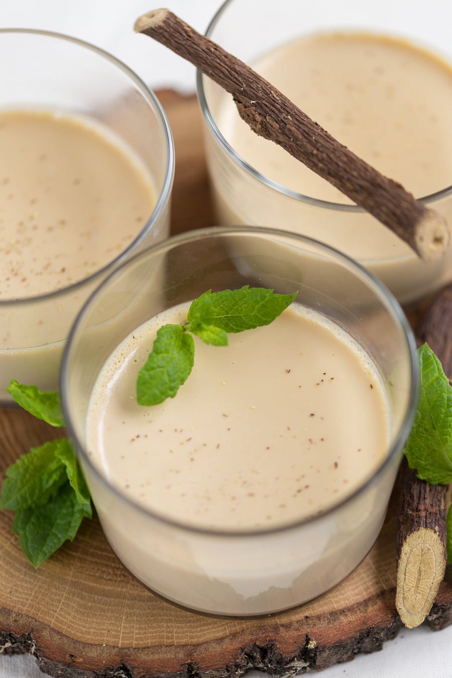Licorice panna cotta closeup. Served with fresh mint leaves in glasses for individual portions.