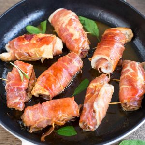 Chicken involtini rolled in prosciutto, cooked in sage butter and white wine in a skillet.