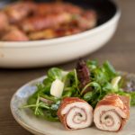 Plated sliced chicken involtini with green salad.