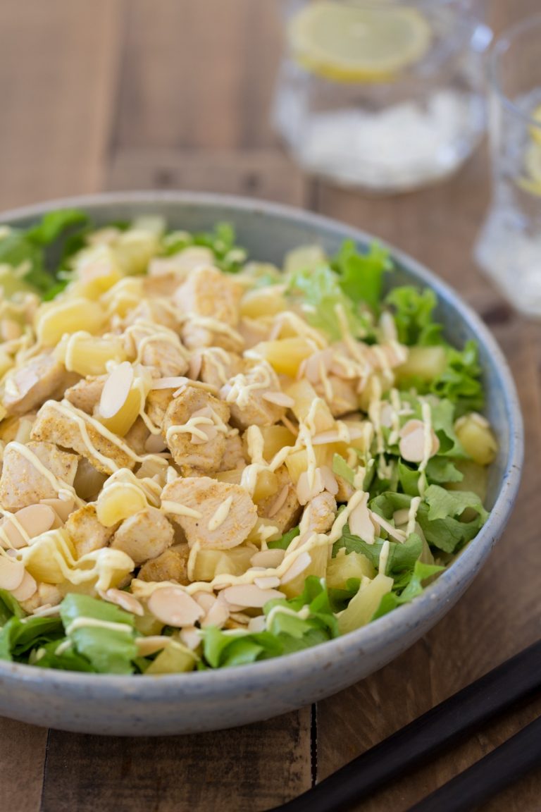 Chicken pineapple salad with curry mayo dressing in a blue bowl.