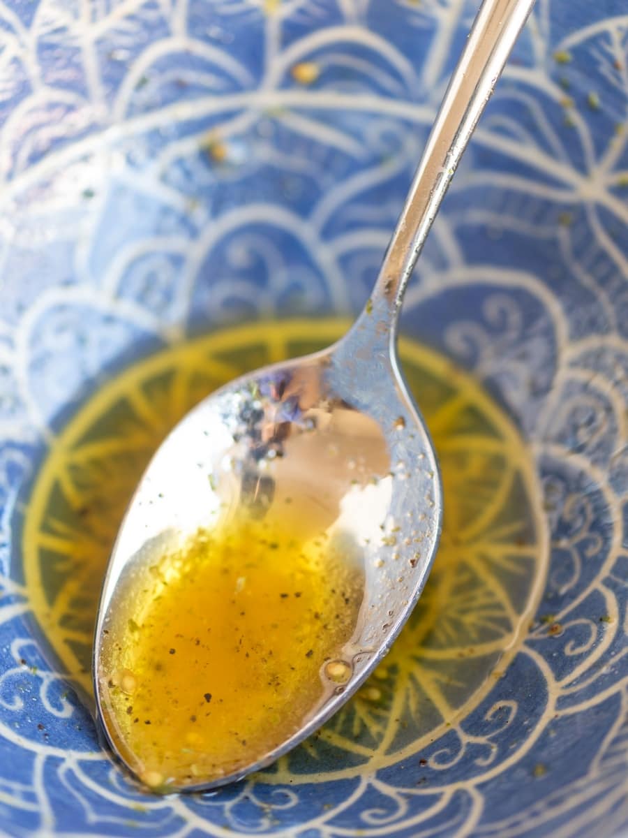 Olive oil condiment leftovers in blue bowl.