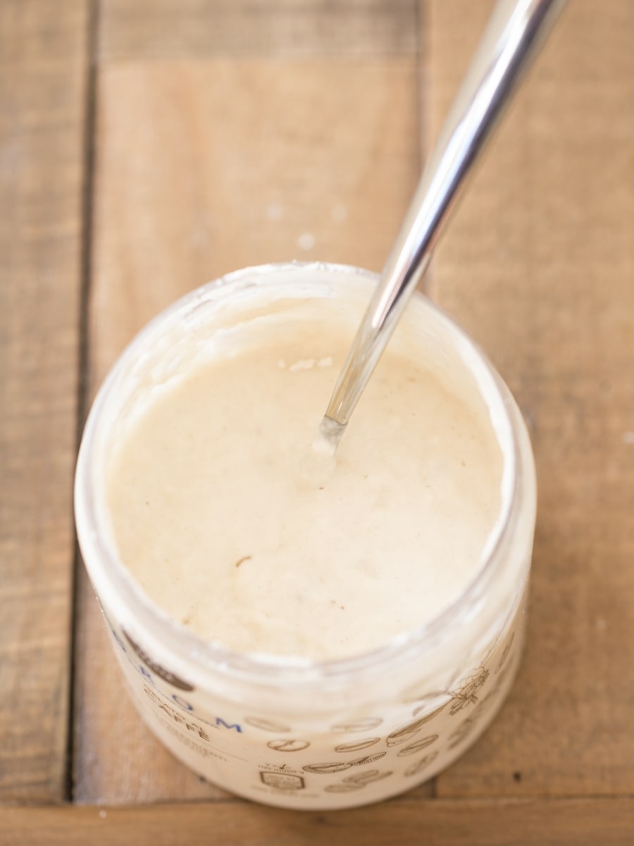 Jar of sourdough starter with spoon in.