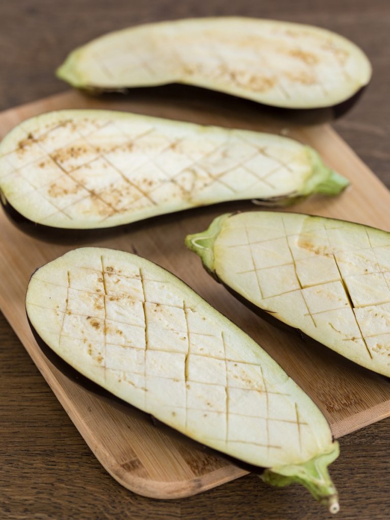 Halved eggplants, flesh scored.