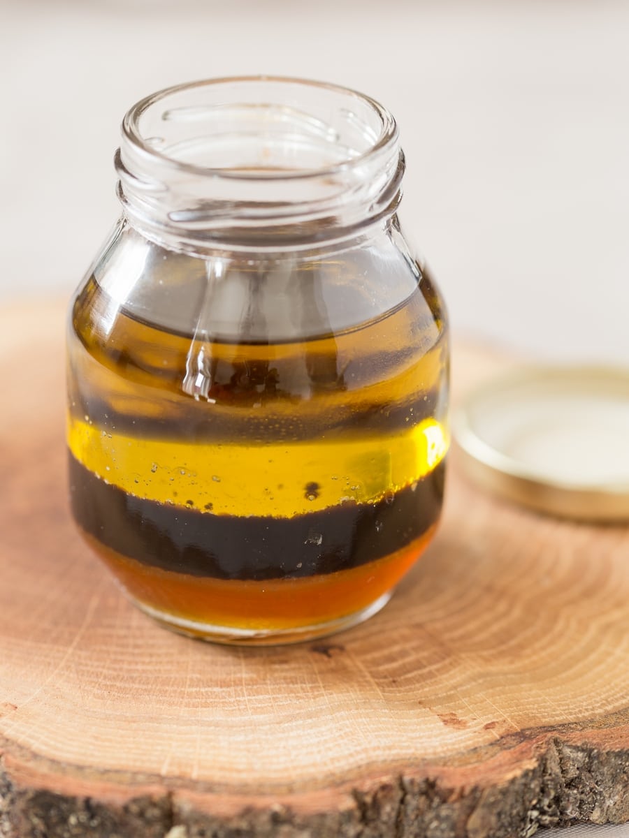 Olive oil, balsamico vinegar and honey layered in a small glass jar.