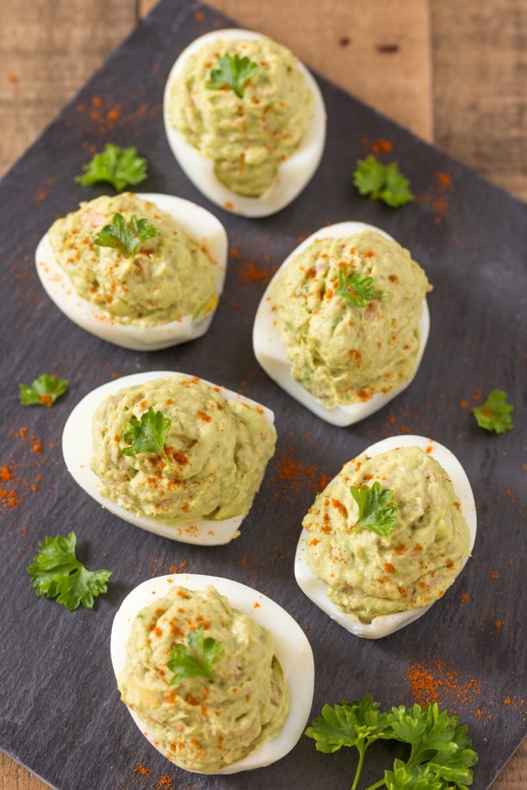 Tuna avocado deviled eggs on a black serving plate.
