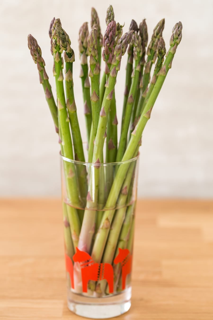 Bunch of green asparagus ina glass of water for longer keeping.