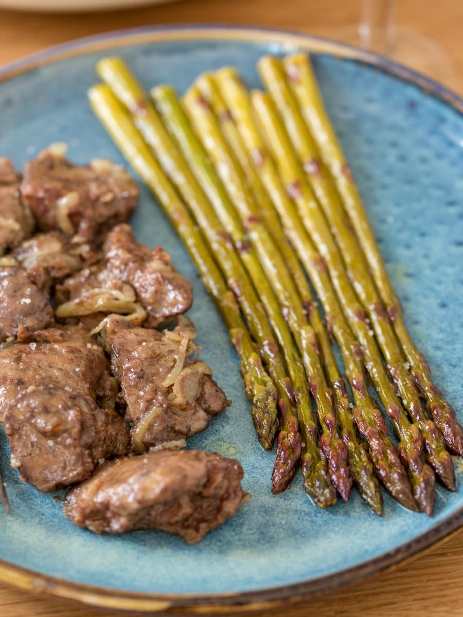 Sautéed white wine asparagus served as side dish to chicken livers with onion.