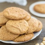 Honey hazelnut meringue cookies stacke on a white serving plate.
