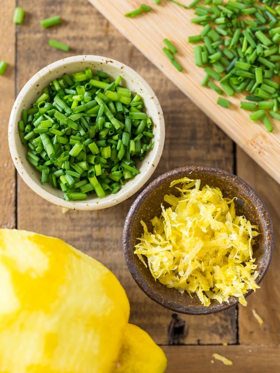 Chopped chives and lemon zest in small bowls.