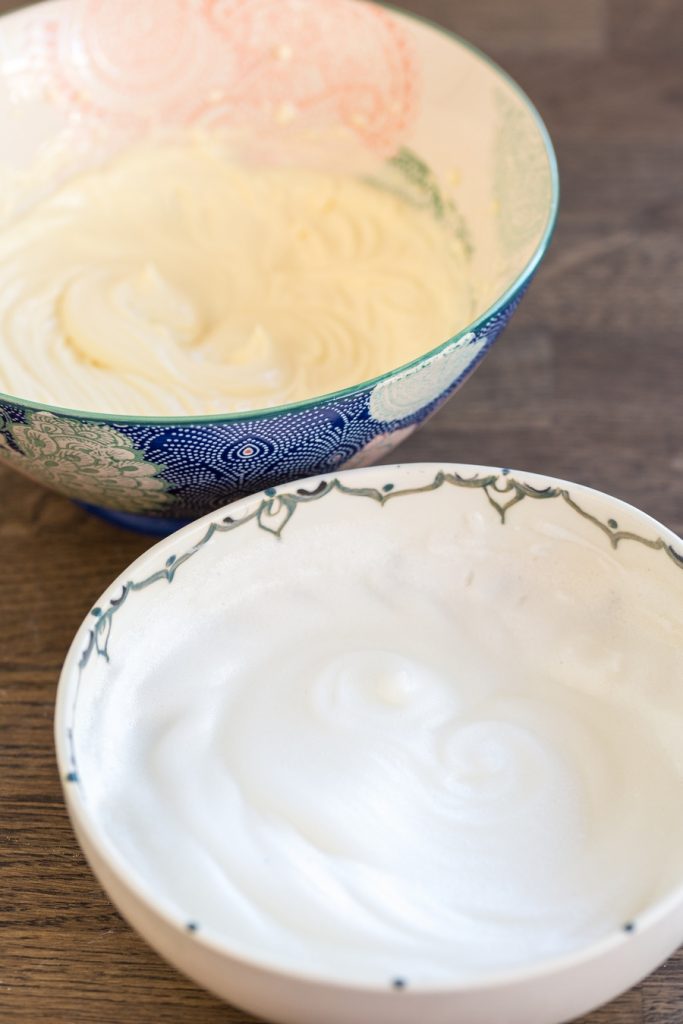One bowl with beaten egg whites, one bowl with mascarpone and egg yolk cream.