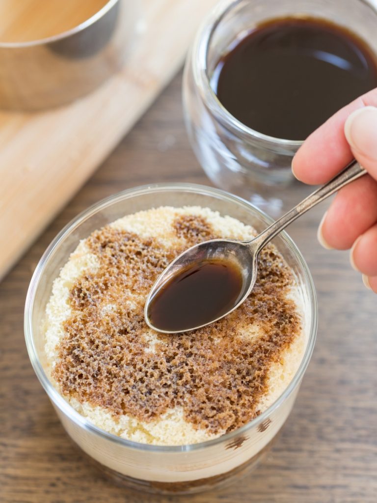 Tiramisu in a glass: soaking the sponge cake with sweetened espresso.