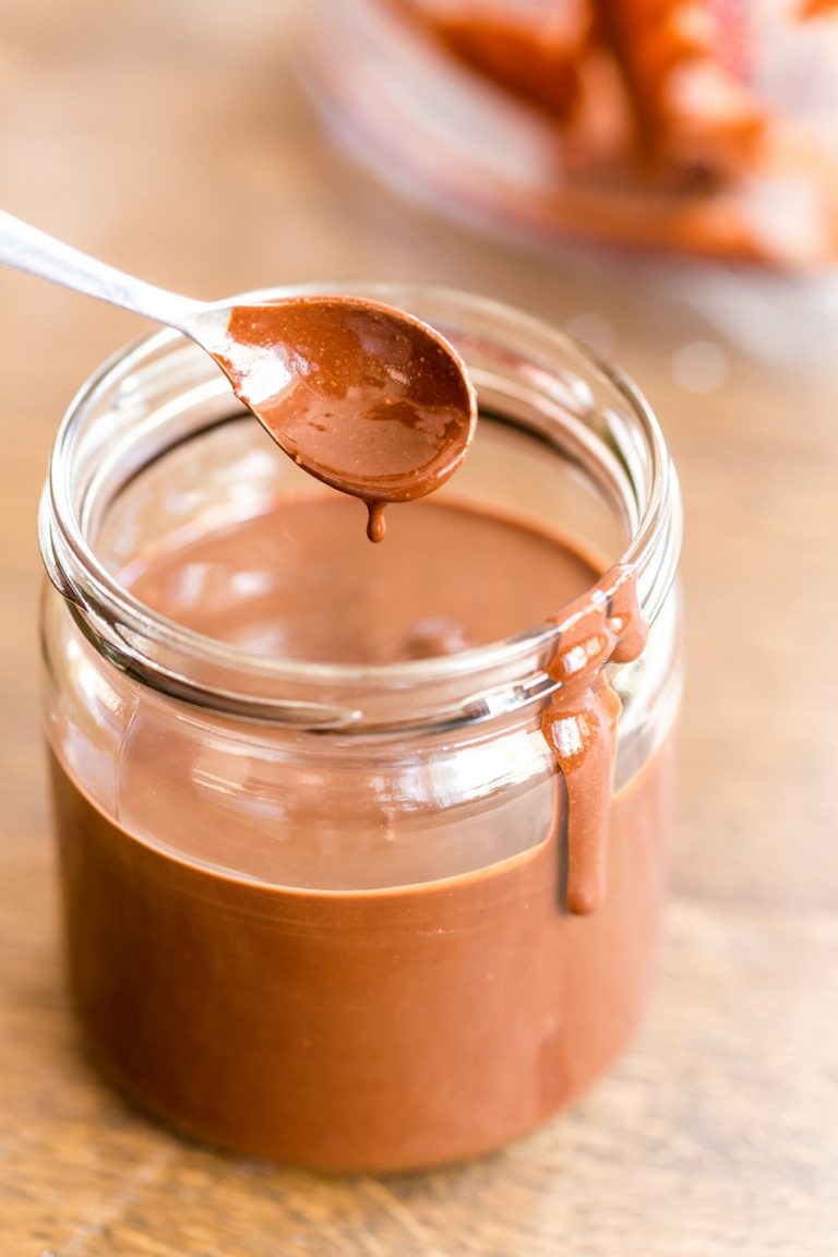 Homemade nutella in a jar, spoon being extracted.
