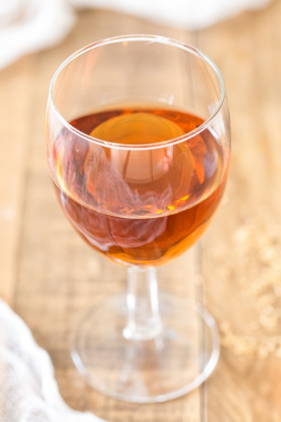 A glass of marsala fortified wine on a wooden table.