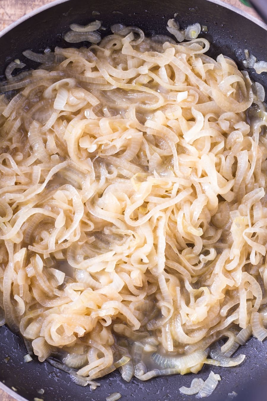 Cooked slices of onion in a skillet.