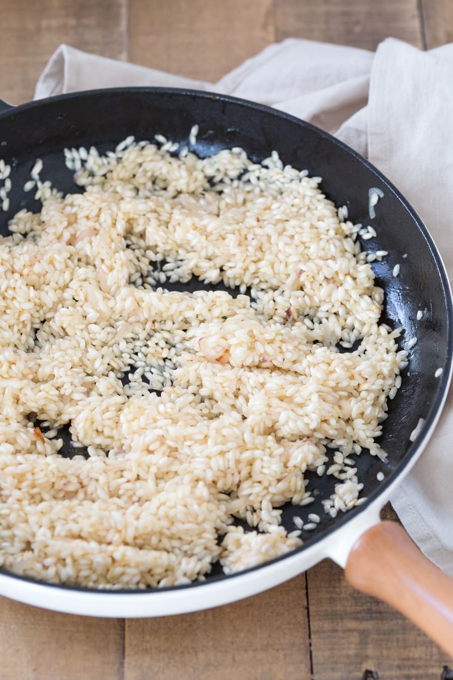 Zucchini cheddar risotto preparation: toasted risotto gets drizzled with white wine.