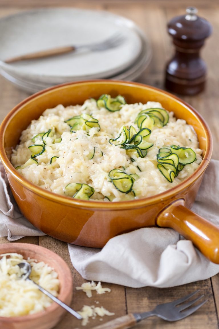 Zucchini cheddar risotto in a brown serving dish.