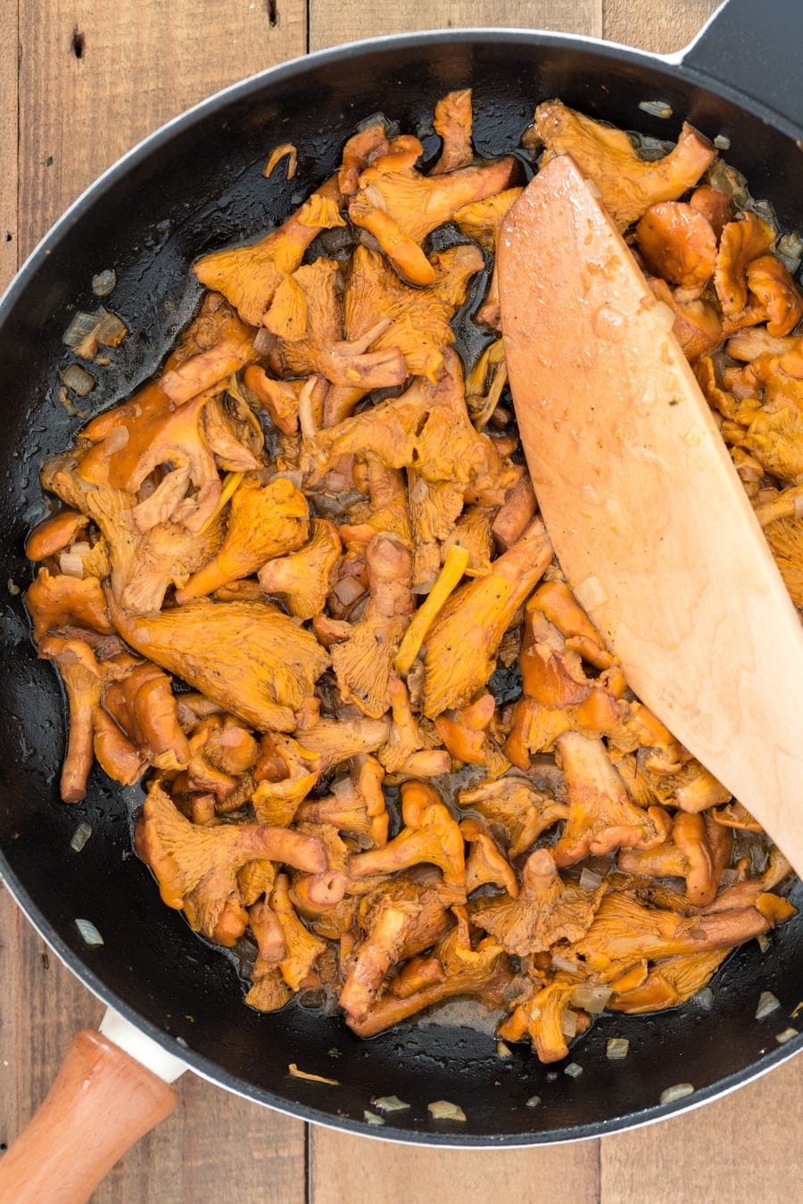 Chanterelles cooked with butter and onion in a skillet.