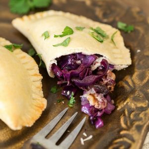 Veggie empanadas showing the filling made with red cabbage, onion, raisins and walnuts.