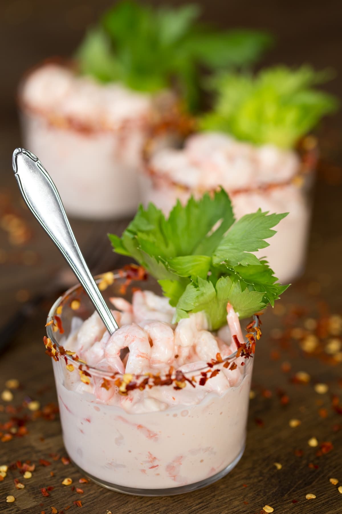 Italian shrimp in cocktail sauce with celery stalk as decoration.