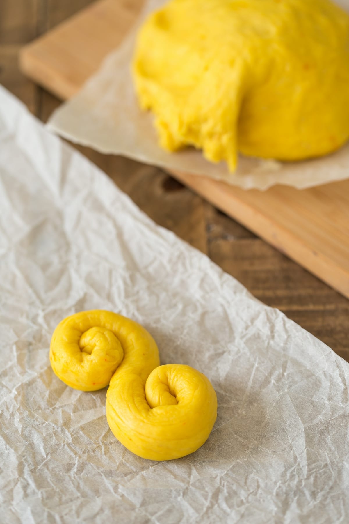 Unbaked saffron bun rolled in an S-shape.