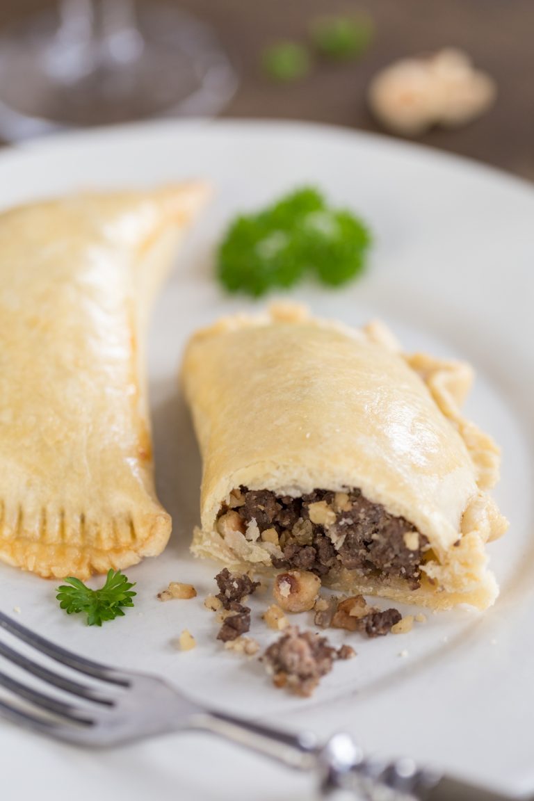 Homemade empanadas with venison and hazelnut filling, with filling coming out.