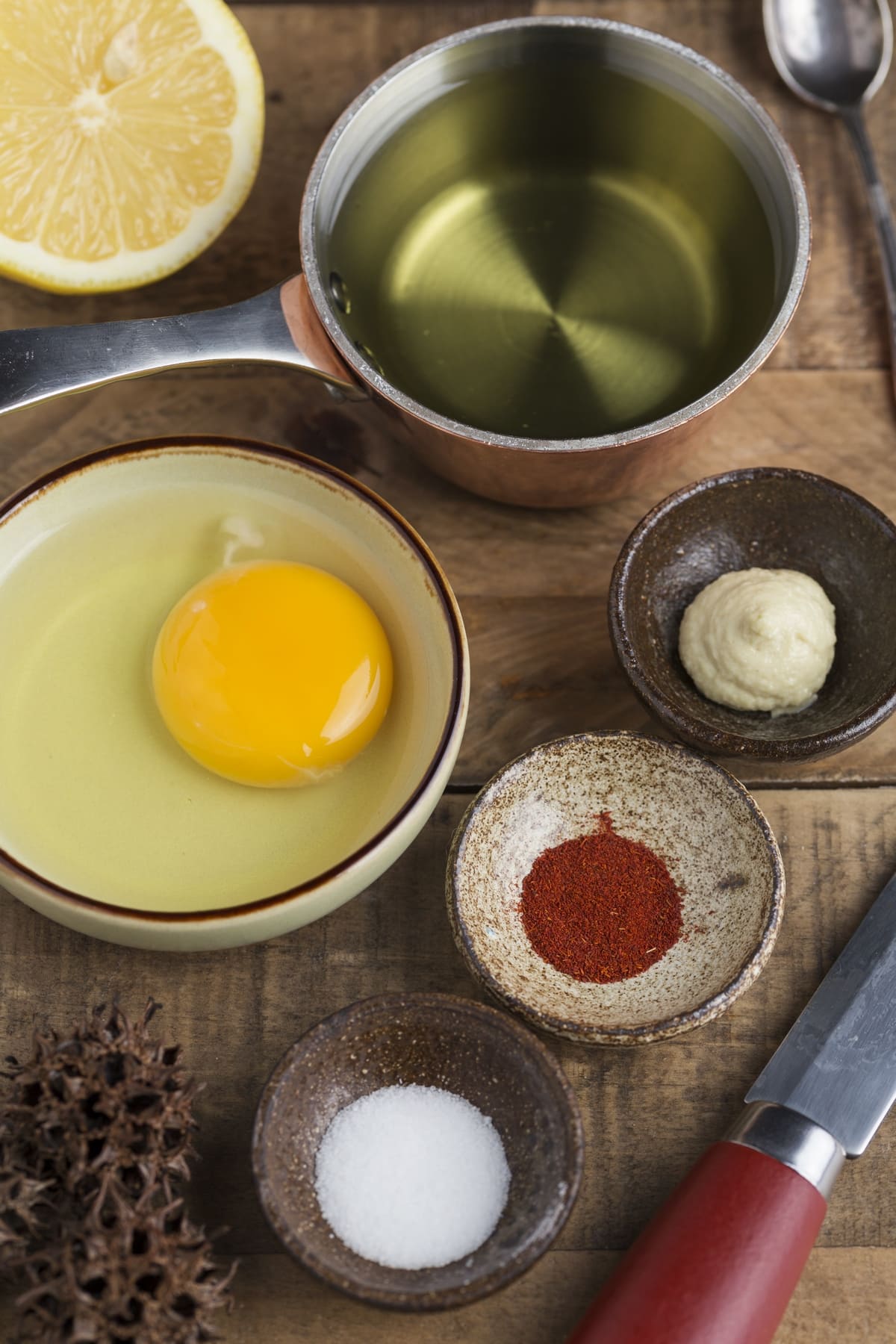 Small bowls containing spices, egg, oil and a half lemon.