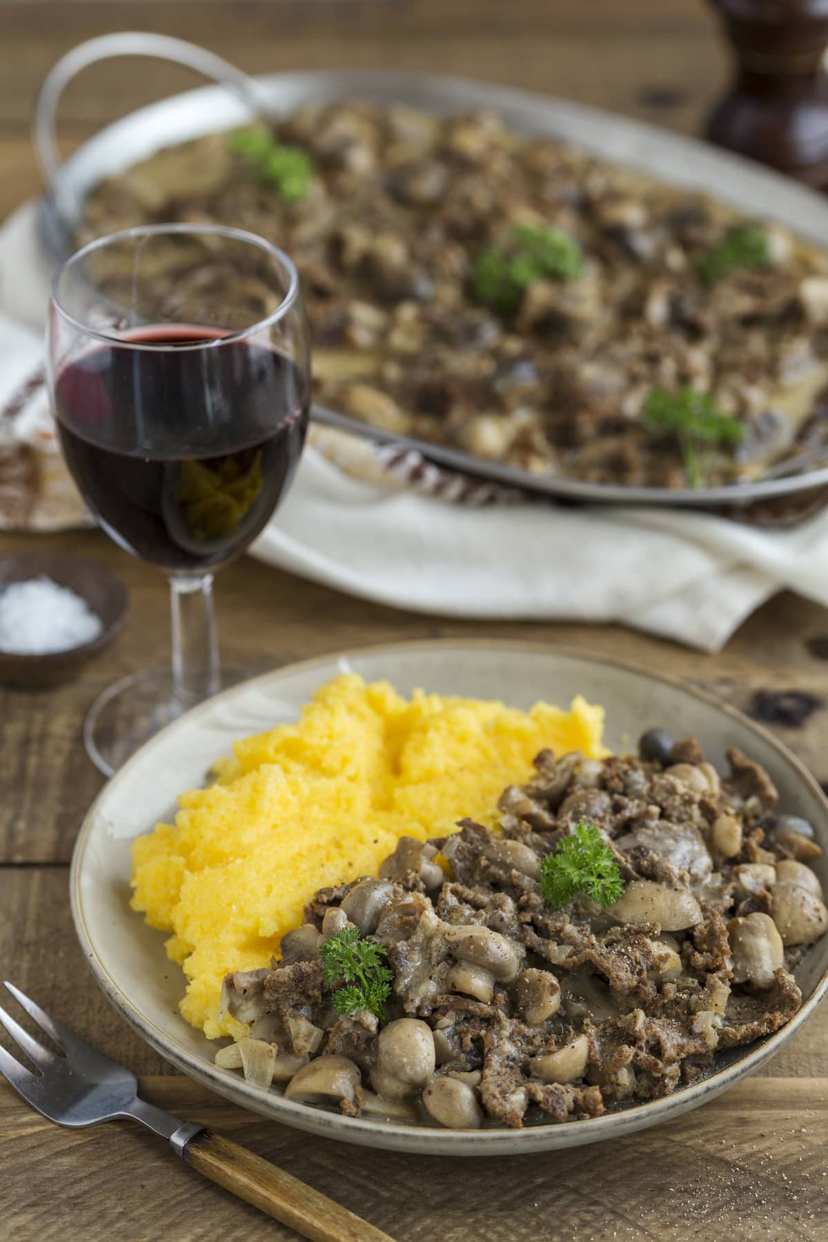 A portion of renskav with polenta, reindeer meat with musrhooms and cornmeal.