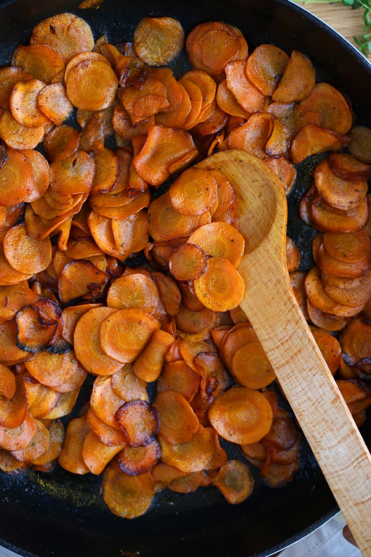 Closeup of soft caramelized carrots in a skillet.