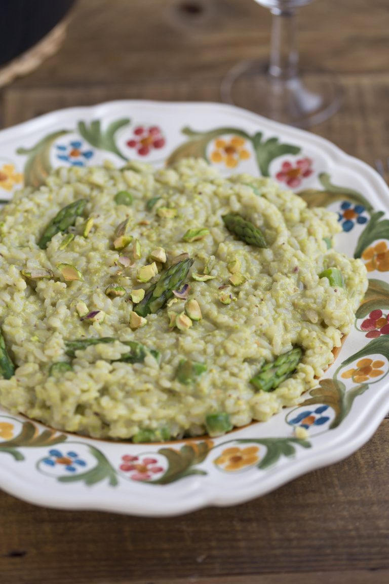 Pistachio asparagus risotto served on a decorated plate.