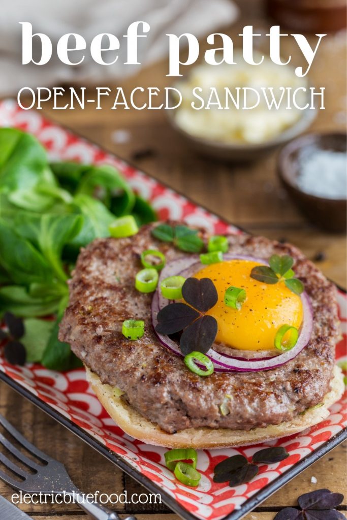 An open-faced hamburger sandwich that features a homemade beef patty on buttered bread topped with a raw egg yolk. A delicious and elegant alternative meal option to your next burger night.
