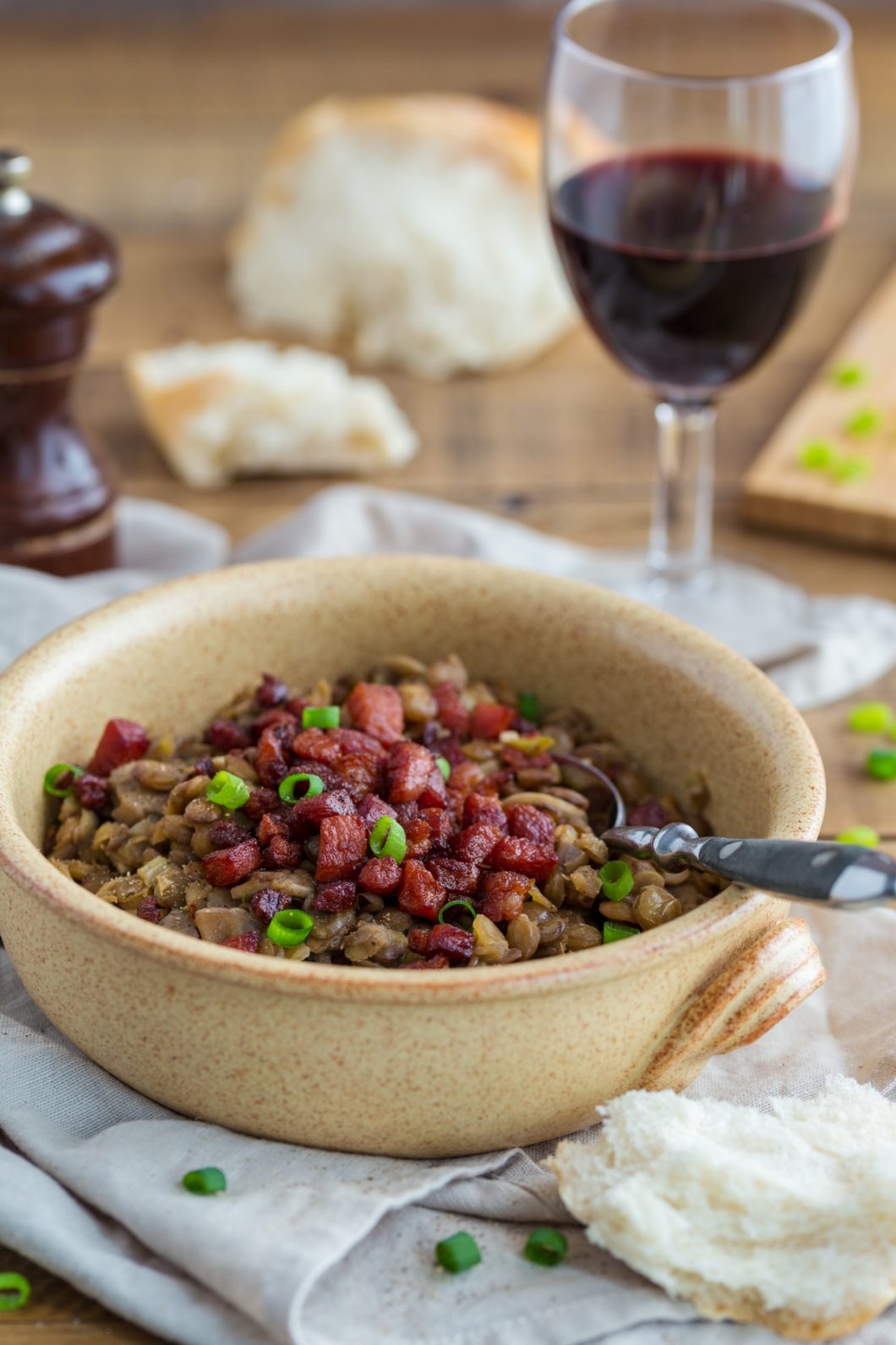 Lentil stew with mushrooms and crispy bacon served with fresh bread and red wine.