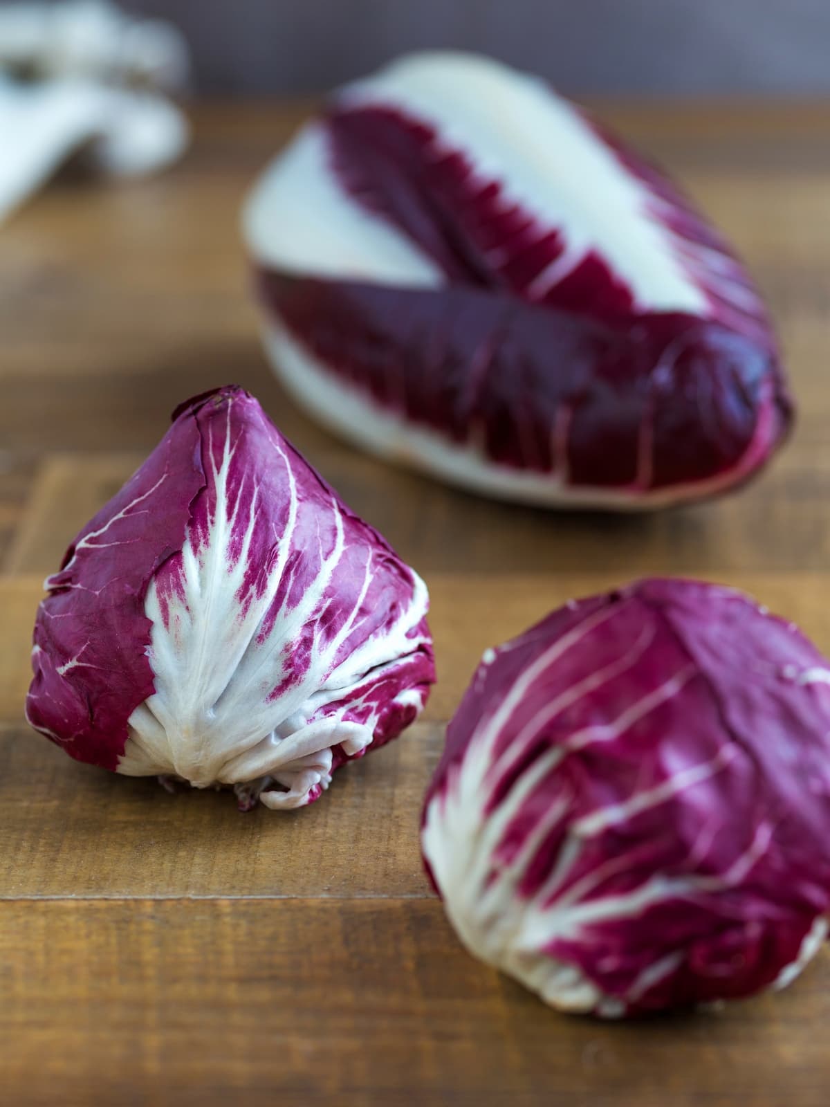 Small round radicchio heads and a long radicchio in the background.
