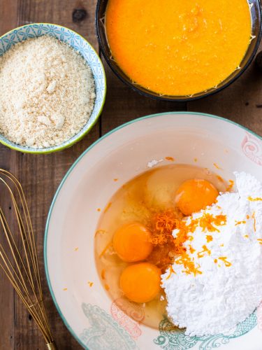 Eggs, sugar and orange zest combined in a bowl.