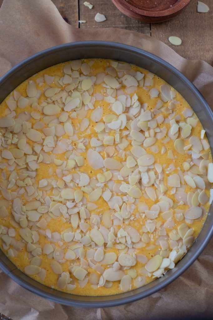 Topping the batter with sliced almonds.