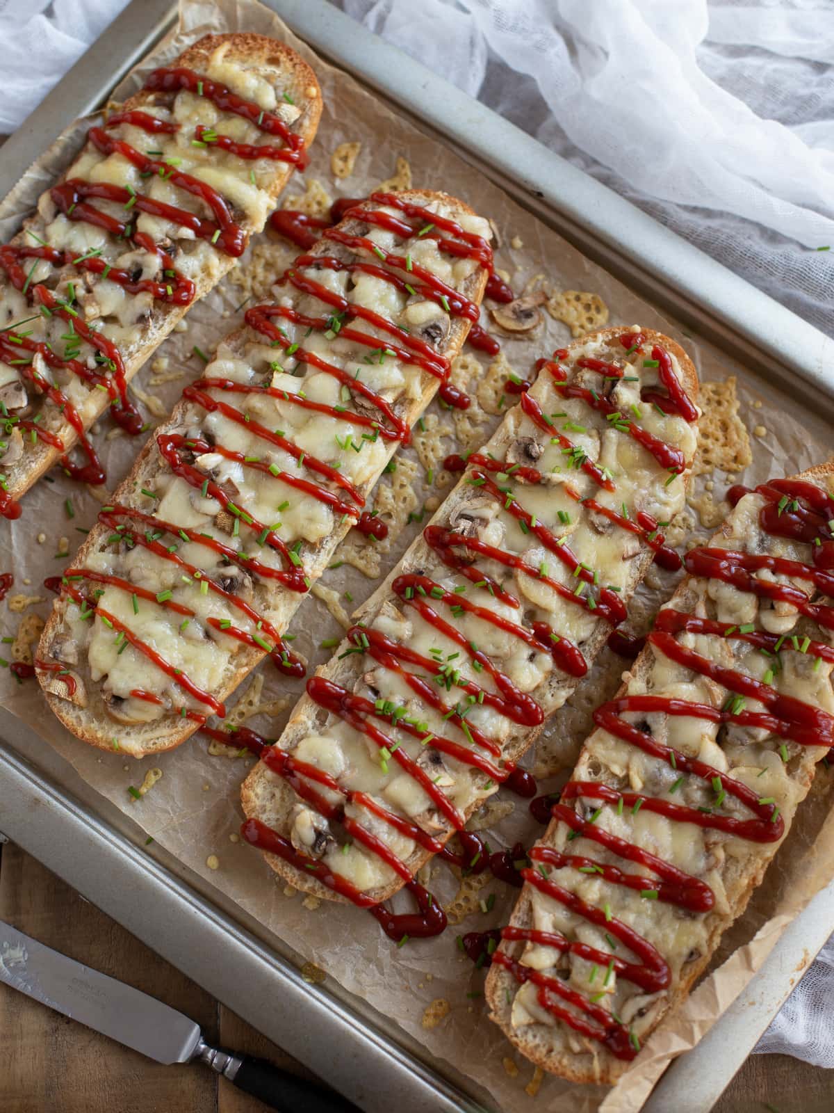 Polish zapiekanka topped with mushrooms and cheese and a drizzle of ketchup.