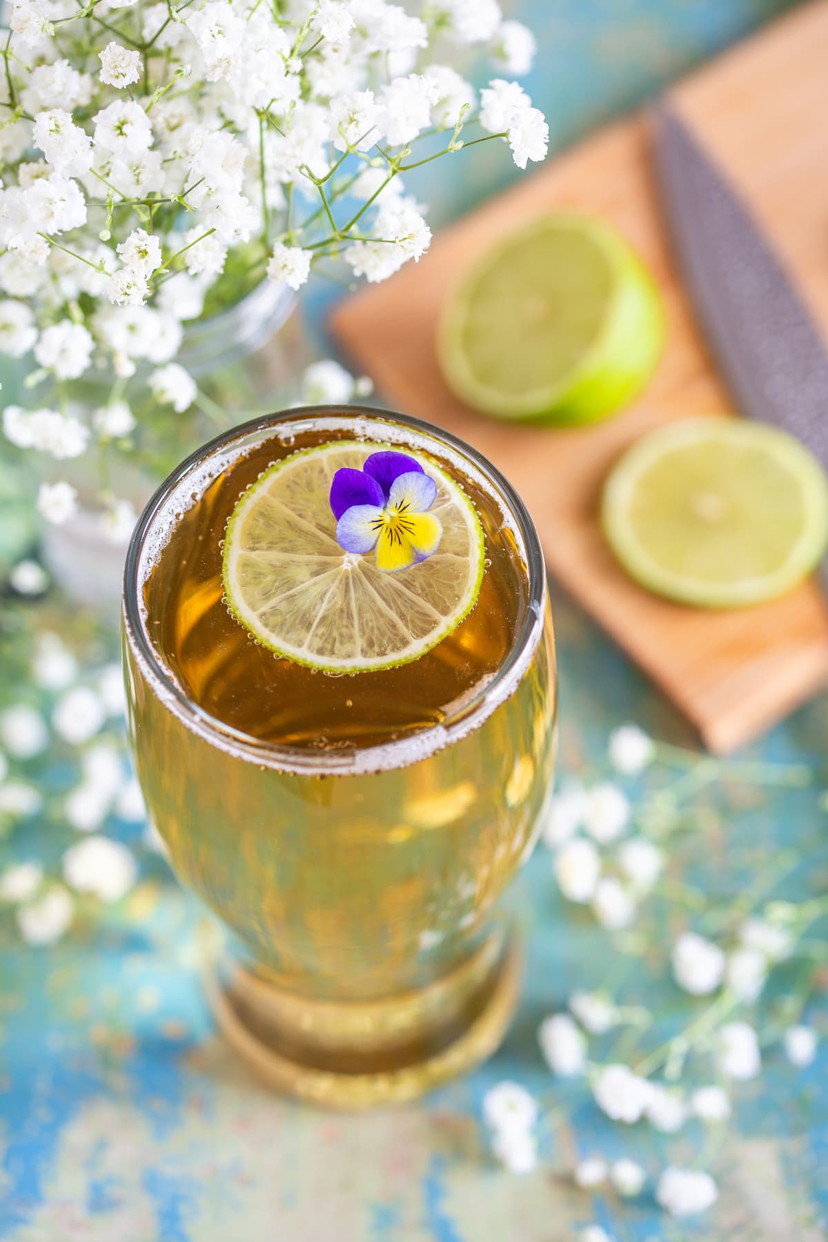 A little edible flower and lime slice decorating the top of the drink.